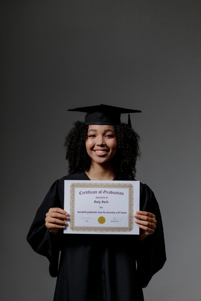 Happy young woman in graduation gown holding a certificate, celebrating success.